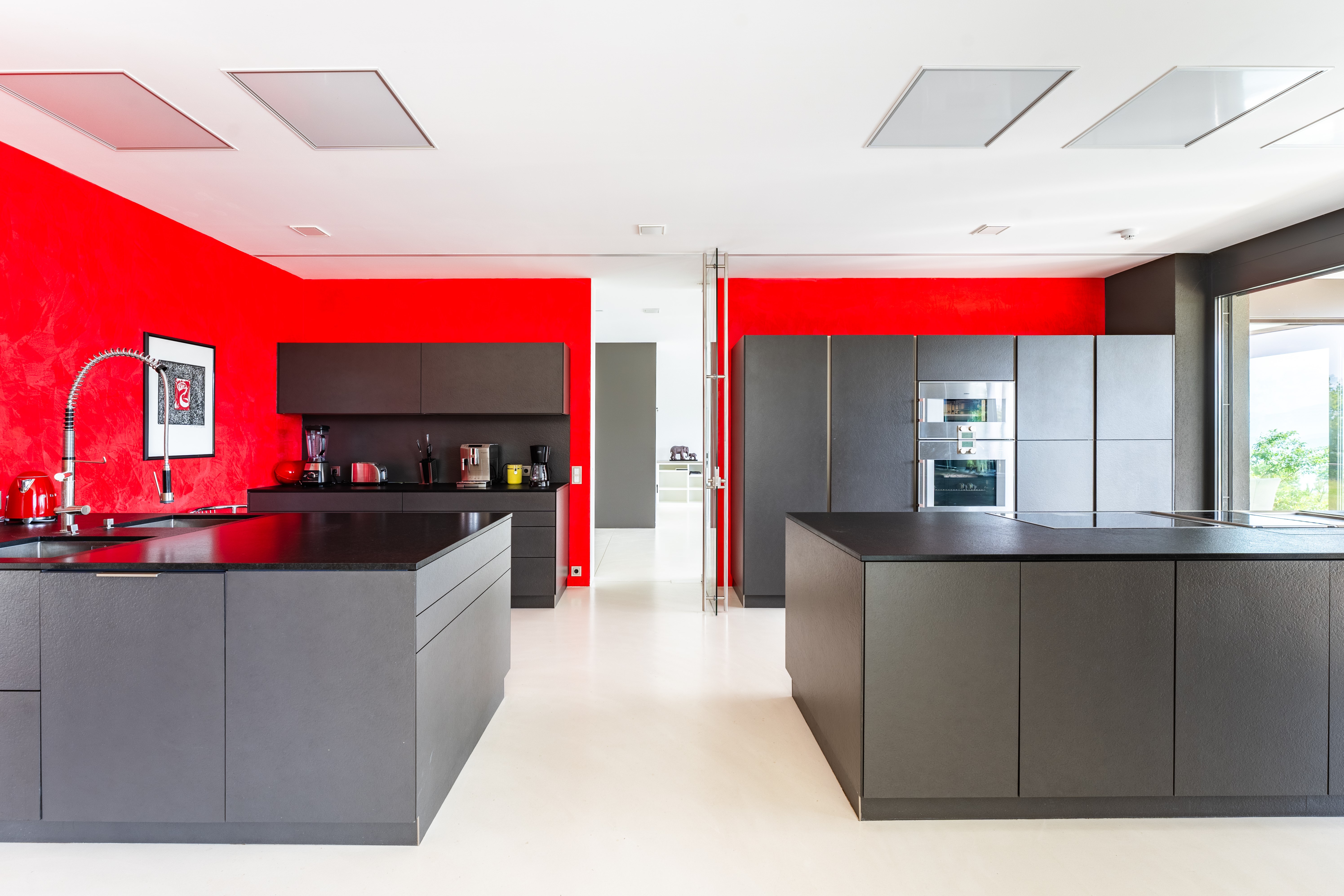 Luxusküche in dunkelrotem Gaggenau-Design mit grafischer Akzentwand