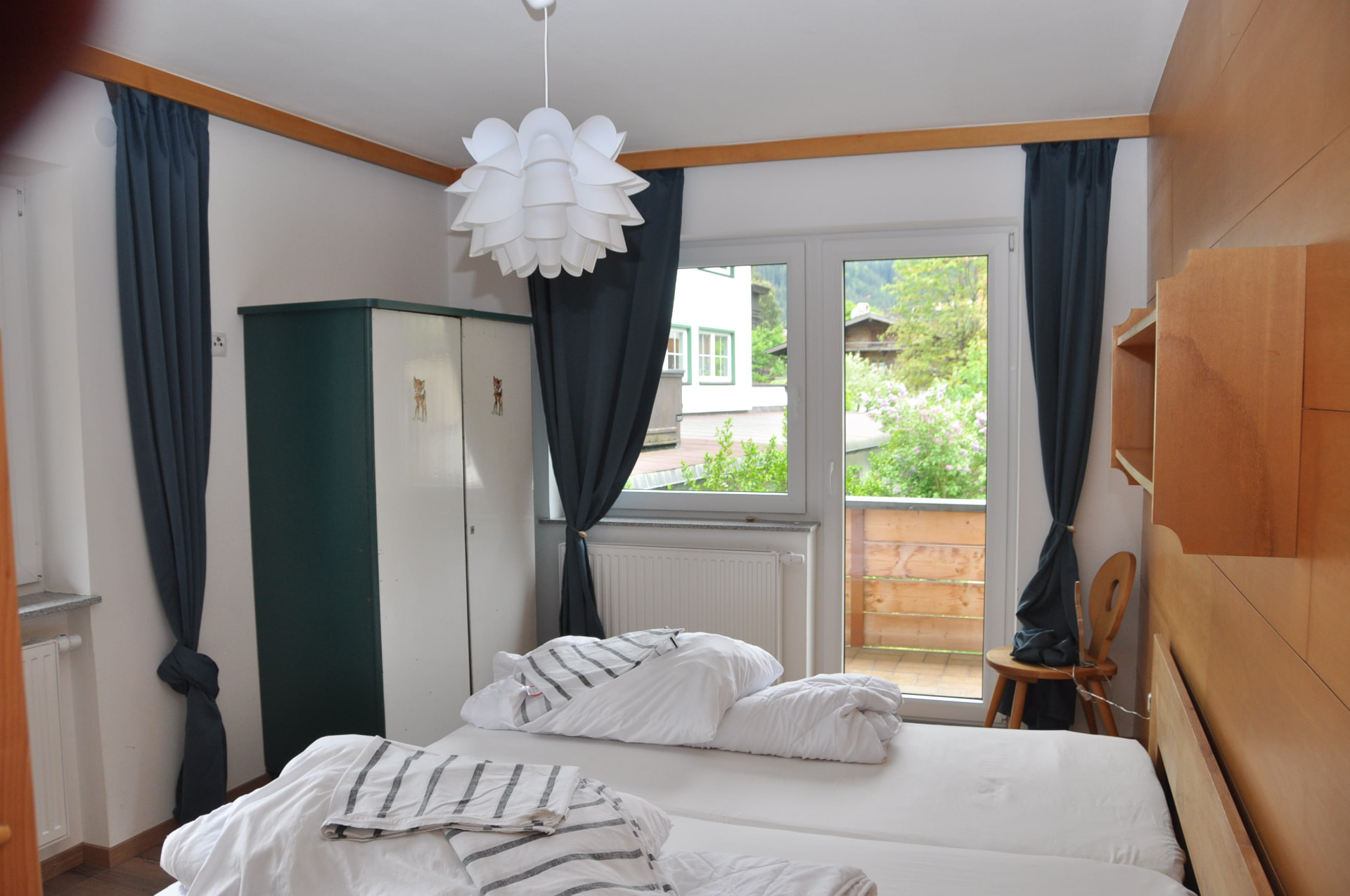 Helles Schlafzimmer mit Balkonzugang und Blick ins Grüne