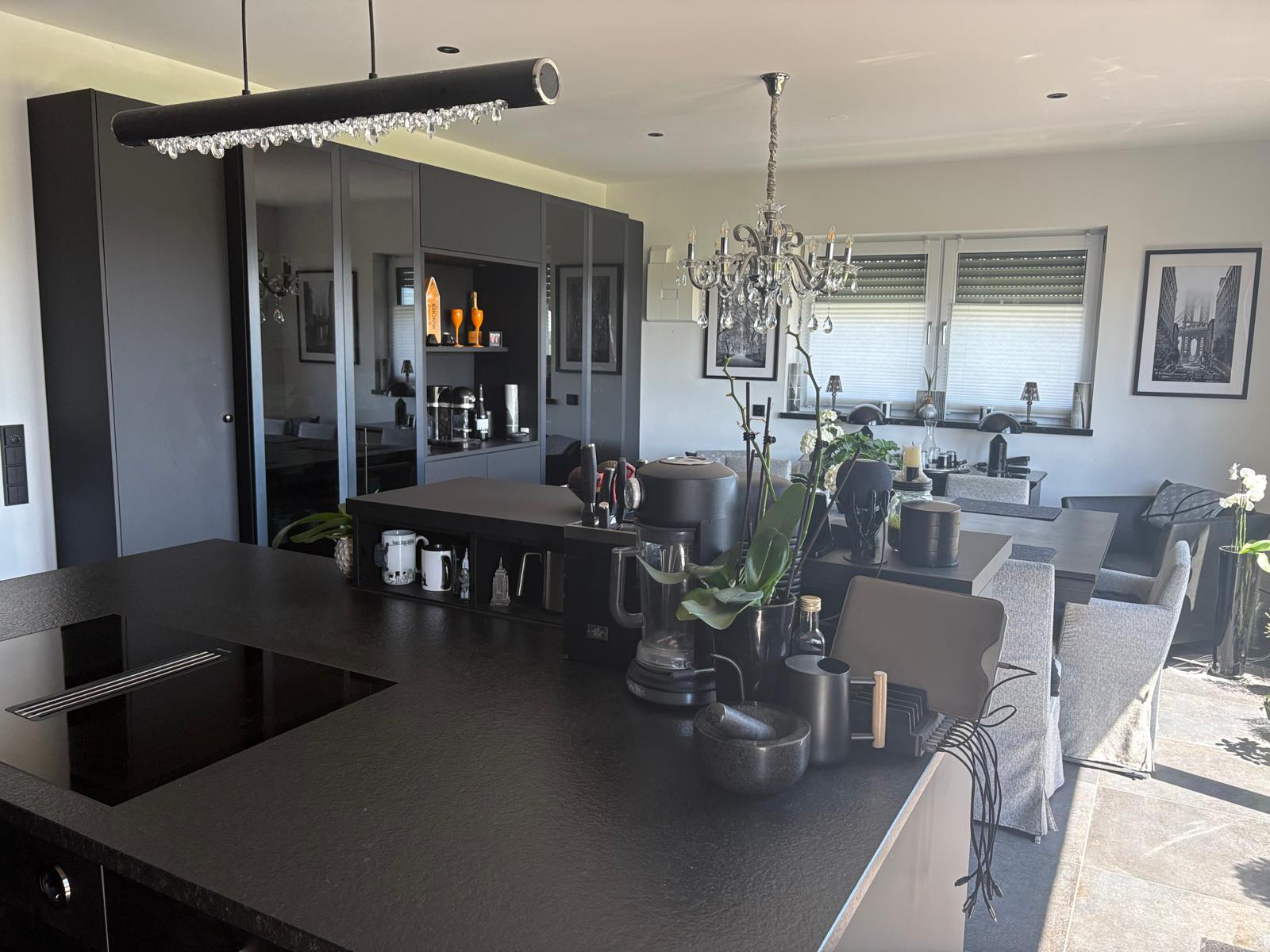 Miele Schreiner-Einbauküche mit Granit Nero Assoluto und Kristallleuchter